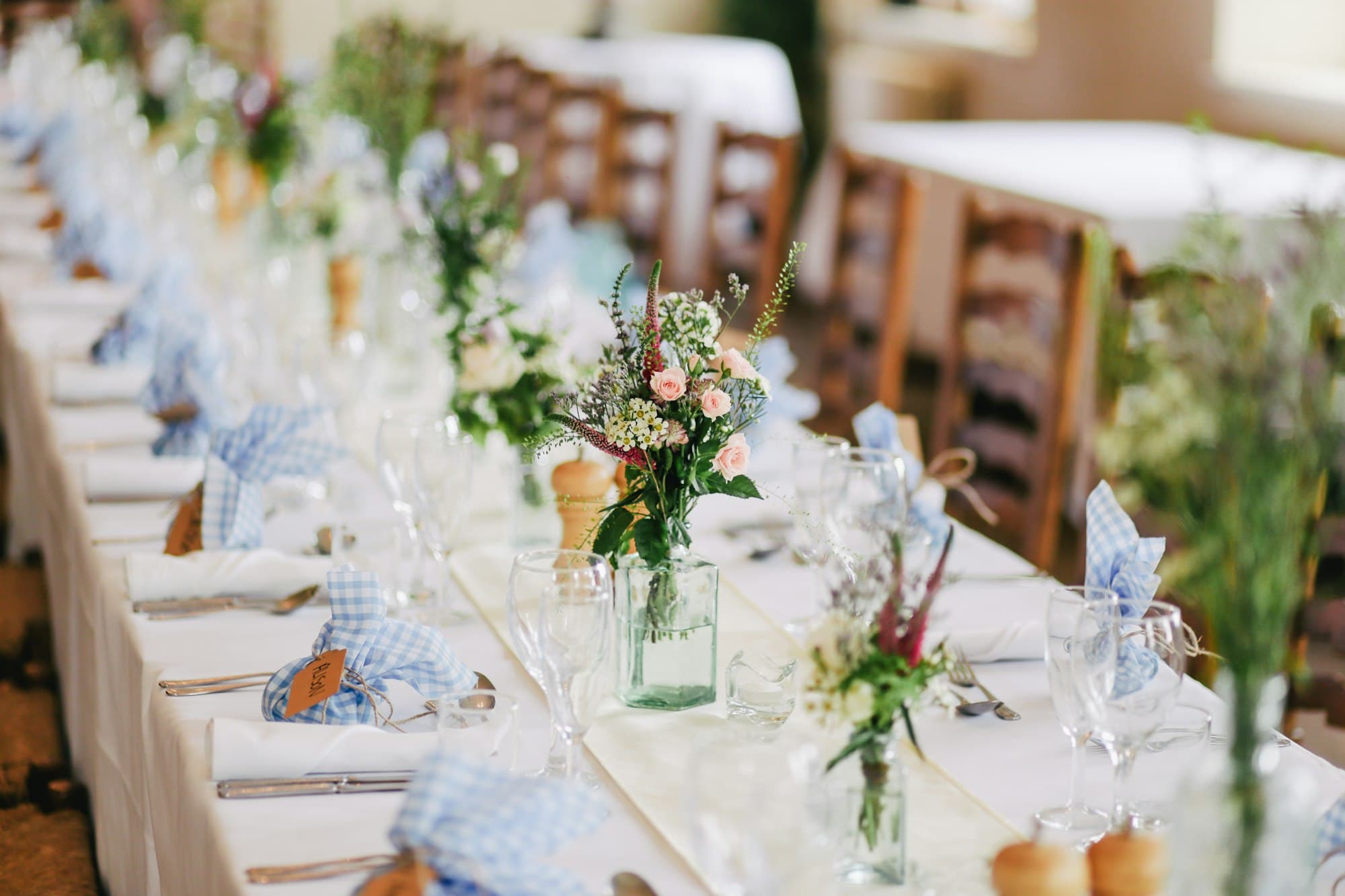 A long reception table set with candles and flowers